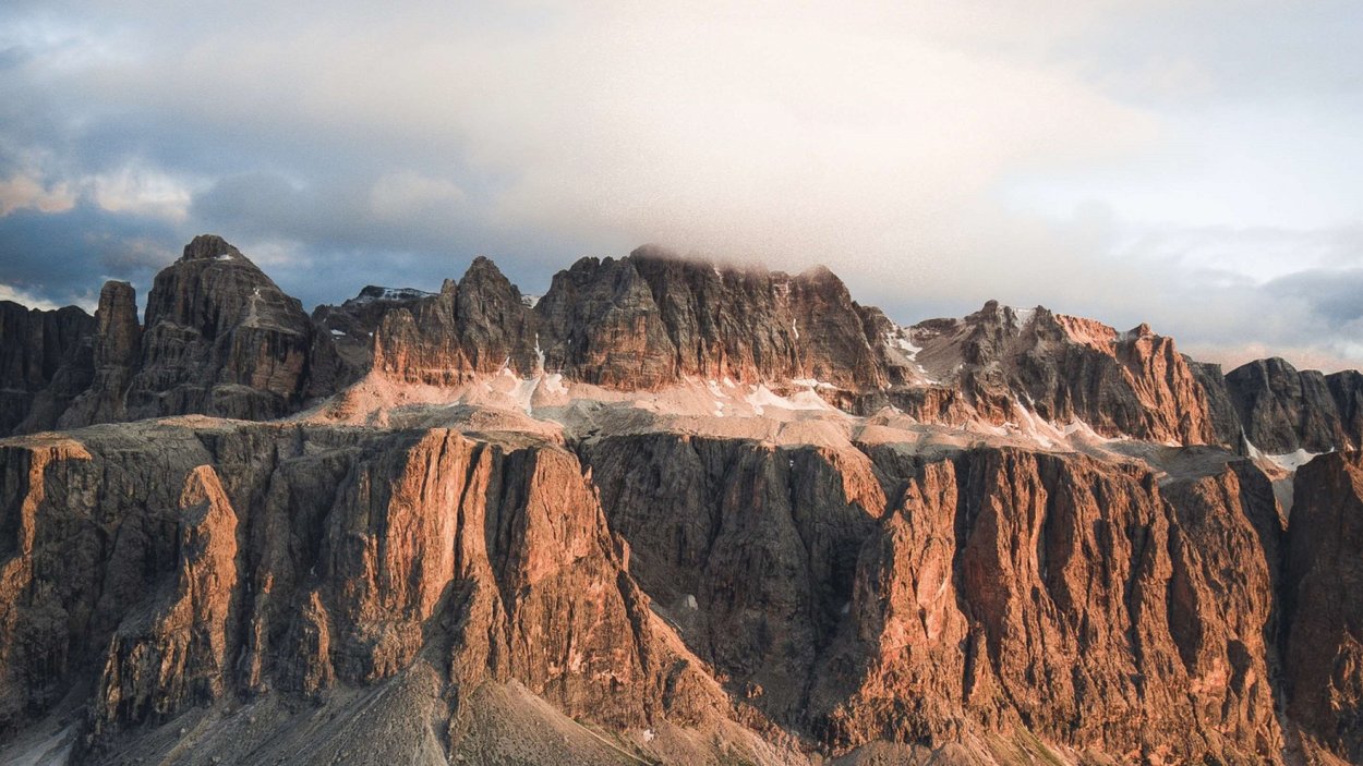Traumhafter Motorradurlaub in den Dolomiten Felsen und Berge mit Wolken bei Sonnenuntergang