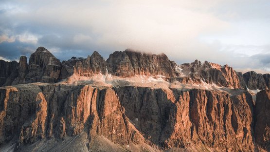Hotels in Alta Badia: Urlaub durch und durch Felsen und Berge mit Wolken bei Sonnenuntergang