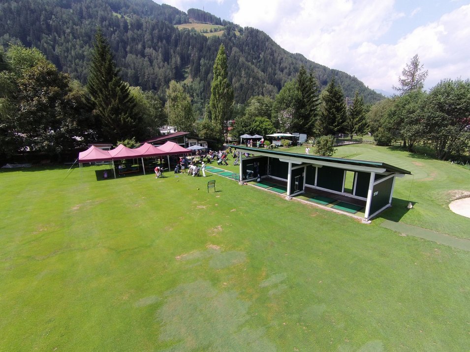 Golf club Vipiteno Campo pratica golf con persone davanti a colline e alberi