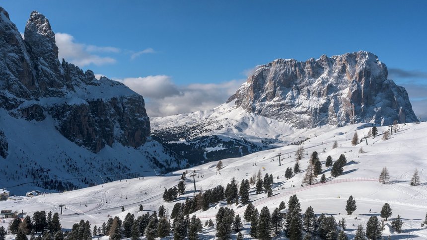 Geheimtipp Hotels in Südtirol 😎☀️ Schneebedeckte Berge und Tannen unter klarem blauen Himmel