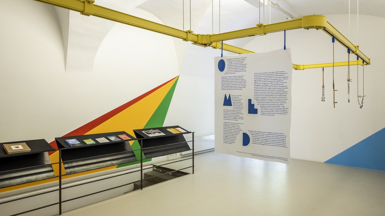 ar/ge Kunst – Bozner Kunstverein Moderne Ausstellung mit hängendem Textbanner und farbigen Wandmalereien in Galerie