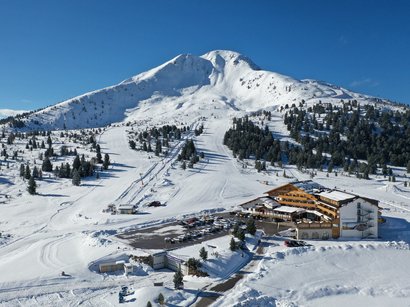 Traumurlaub in den Hotels in Tramin Schneebedeckter Berg mit Skilift und Berghotel unter klarem blauem Himmel