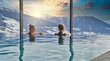 Day Spa in den besten Wellnesshotels Südtirols Zwei Frauen entspannen im Infinity-Pool mit Aussicht auf schneebedeckte Berge im Sonnenuntergang