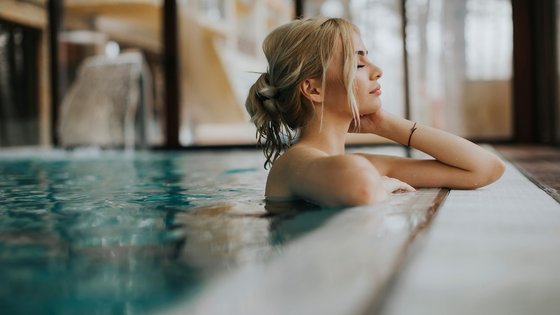 Hotel Hirzer Donna rilassata in piscina coperta appoggiata al bordo con gli occhi chiusi