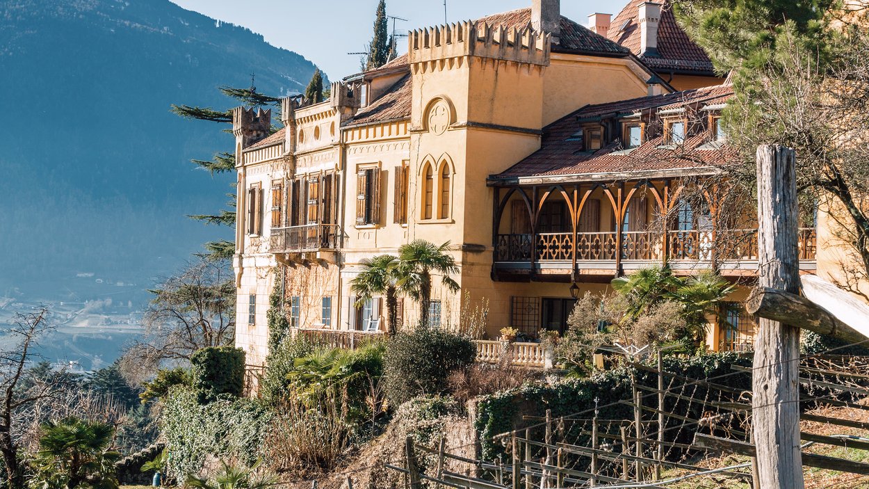 Castello Rametz a Merano Castello storico con giardino e montagna sullo sfondo alla luce del sole