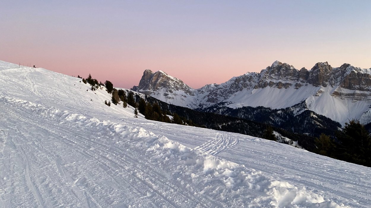Rodelspaß auf dem Brixner Hausberg Verschneite Berglandschaft mit klarer Abenddämmerung und Bergen im Hintergrund