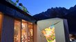 Dolomythos: innovatives Museum im Hochpustertal Eingang des Dolomythos Museums mit Dinosaurierfiguren auf dem Dach bei Abendstimmung