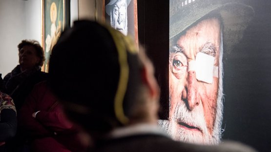 Il Museo Provinciale Miniere di Cadipietra Visitatori guardano un grande ritratto di un uomo anziano con occhio bendato in una galleria