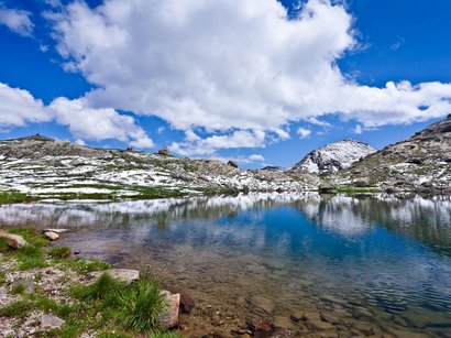 Mit Ausblick auf Meran: die Mutspitze Bergsee mit Schnee, Felsen und blauem Himmel mit Wolken