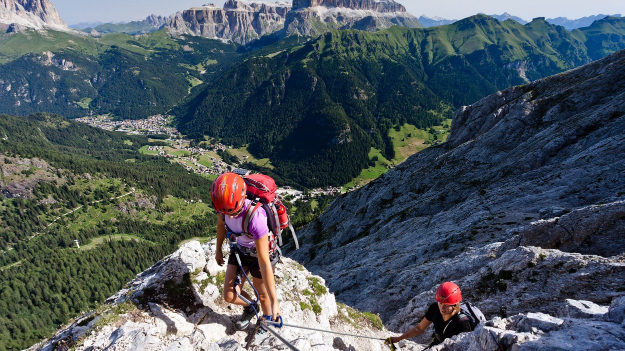 Vie ferrate in Alto Adige Due scalatori con caschi arrampicano una parete rocciosa sulle Alpi
