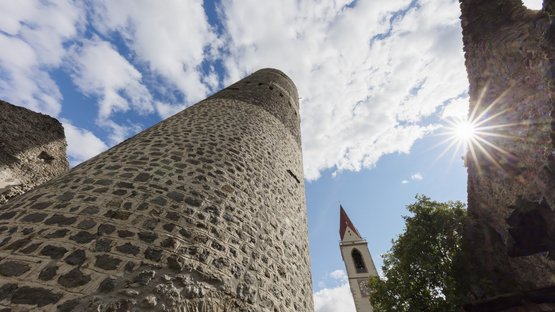 La Torre Fröhlich a Malles Venosta Torre di pietra storica e campanile sotto cielo nuvoloso con sole