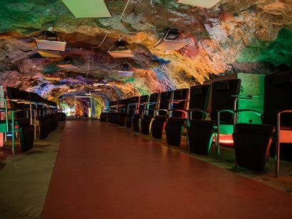 Das Bergbaumuseum in Steinhaus Unterirdischer Kinosaal mit bunten Lichtern und Reihen von Sitzen