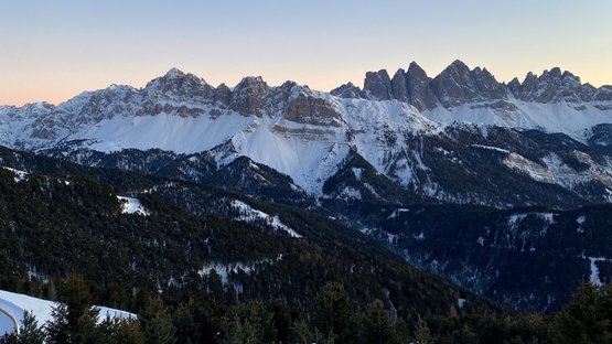 Rodelspaß auf dem Brixner Hausberg Schneebedeckte Berge und Wälder bei Sonnenuntergang in den Alpen