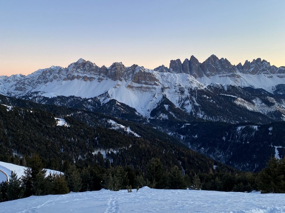 Rodelspaß auf dem Brixner Hausberg Schneebedeckte Berge und Wälder bei Sonnenuntergang in den Alpen