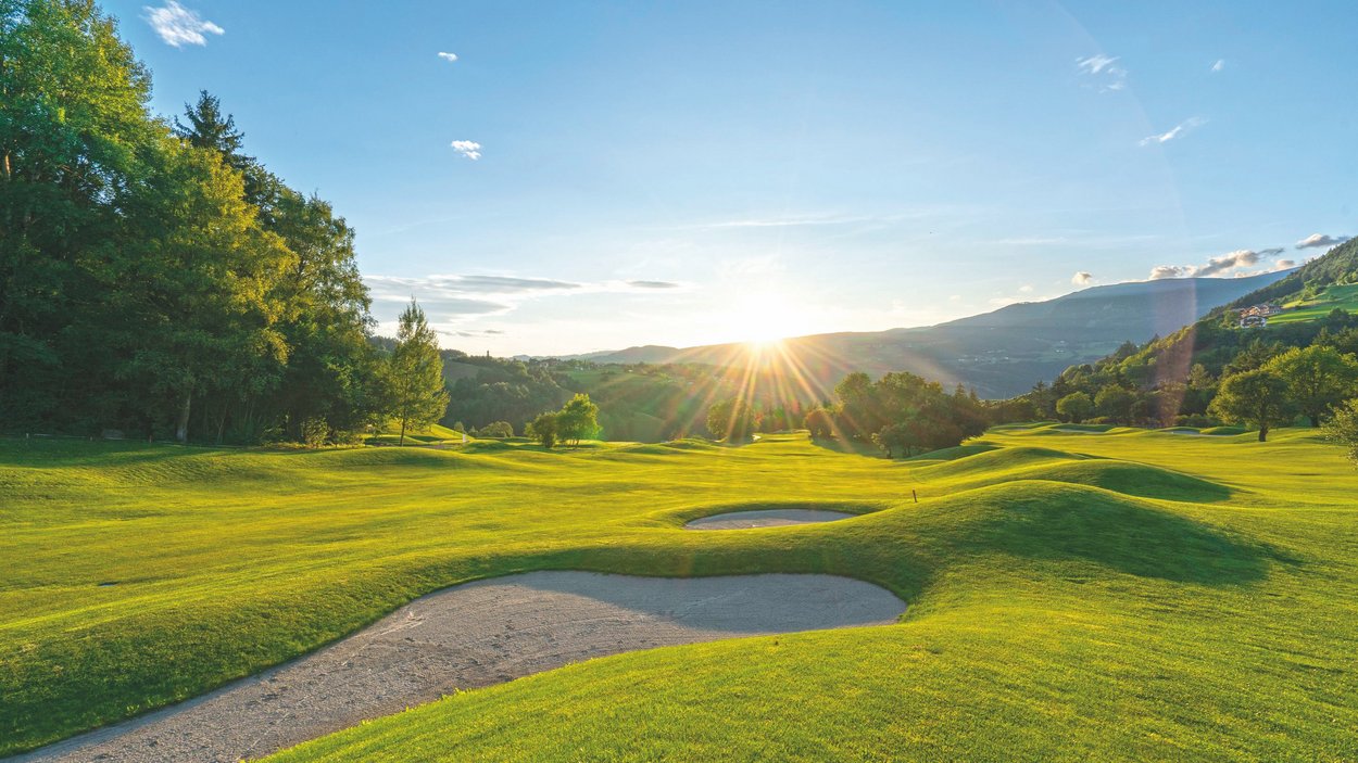 Golfclub St. Vigil-Seis Golfplatz mit Sandbunkern bei Sonnenuntergang in hügeliger Landschaft