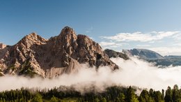 Hotel sulle Dolomiti Paesaggio montano con foresta nebbiosa sotto cielo azzurro limpido